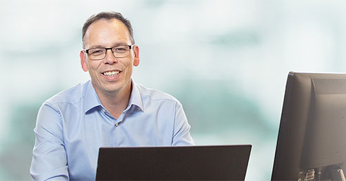 A man sitting at a computer smiling