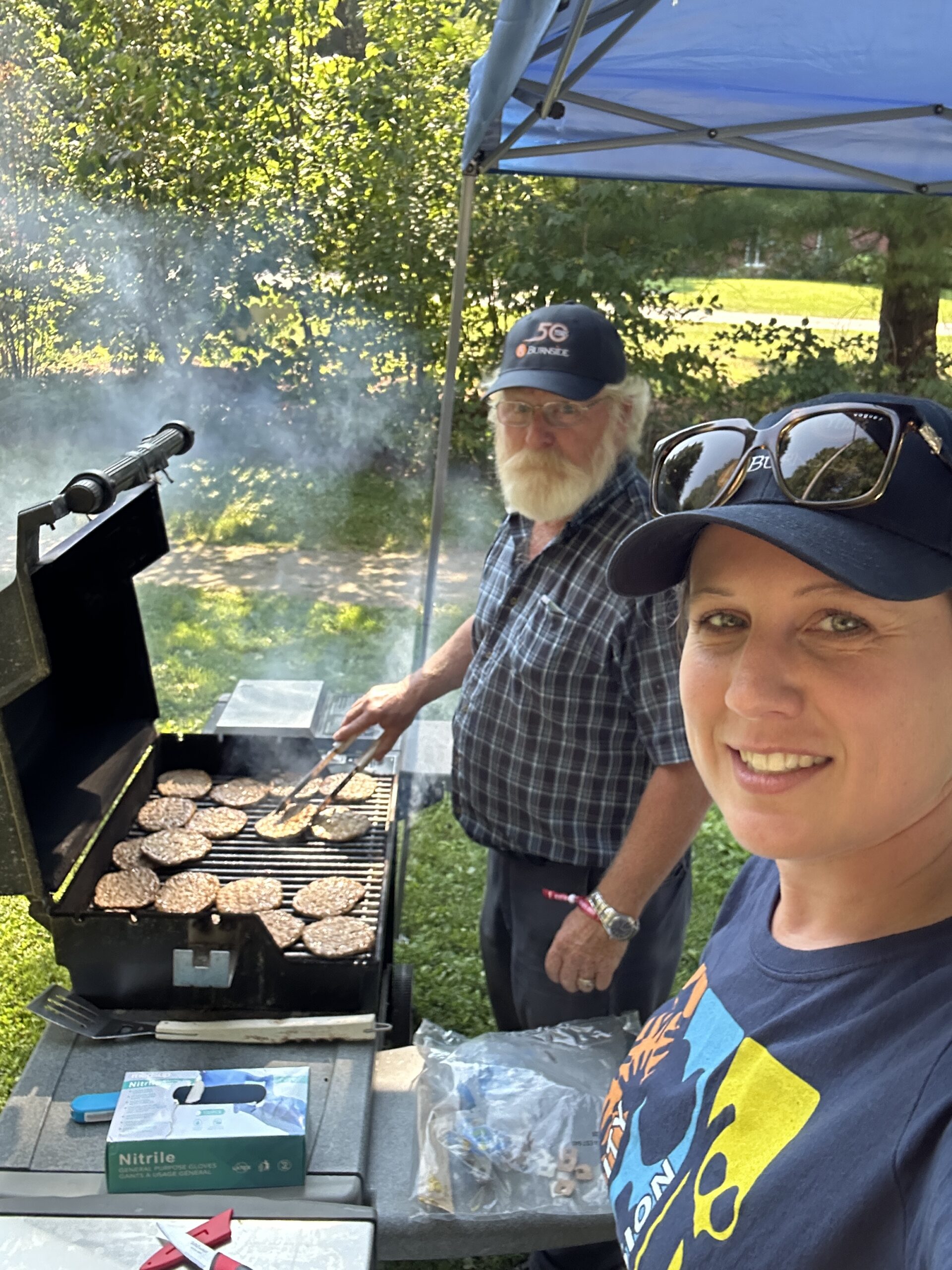 Two people standing at a BBQ