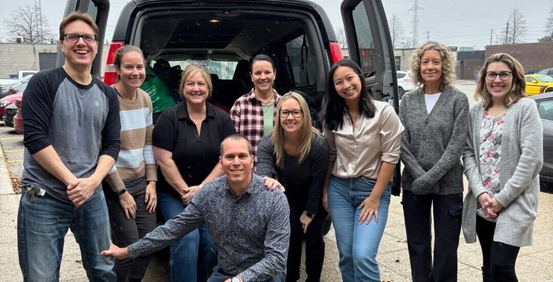 A group of colleagues standing in front of a van